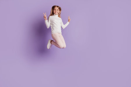 Photo of positive adorable lady jump raise fists celebrate victory wear white jumper posing on...