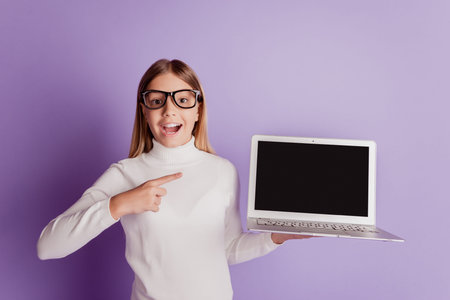 Cute little girl child hold laptop computer direct finger open mouth