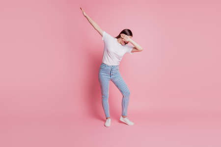 Portrait of a happy young woman dancing make cool move dabの写真素材