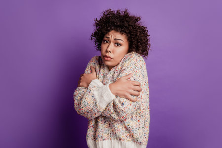 Beautiful unhappy girl freezing cold weather wear sweater isolated on purple background