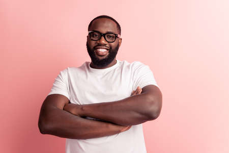 Portrait of young man crossed hands posing in glassesの写真素材