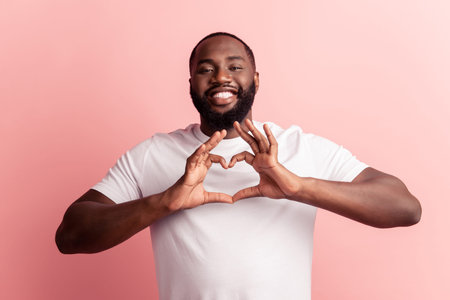 Portrait of happy lovely man fingers show like heart gesture