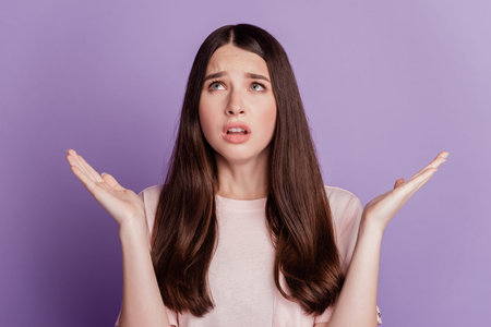 Portrait of sad unhappy woman raise palms look empty space isolated on violet background