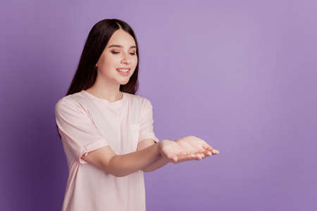 Profile portrait of tender lovely adorable girl hands hold empty space posing on purple wallの写真素材