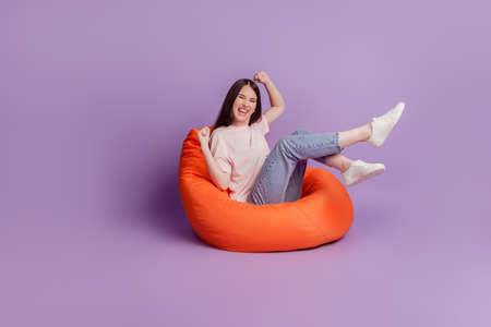 Photo of crazy girl raise fists celebrate victory on purple backgroundの写真素材