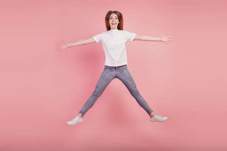 Photo of active girl jump high up star shape funny pose on pink backgroundの写真素材