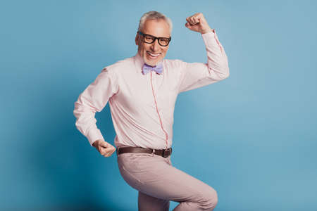 Photo of aged good mood guy raise fists winner concept isolated on blue background.の写真素材