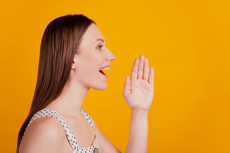 Profile portrait of promoter announcer lady look empty space scream open mouth on yellow background