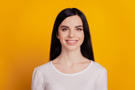 Casual portrait of young attractive european girl smiling happy positive isolated over yellow color...