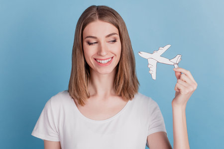 Portrait of curious tender tempting lady hold white paper plane look on blue background