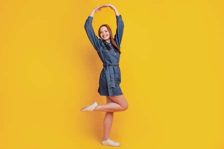 Portrait of elegant lady dance ballet wear jeans mini dress footwear on yellow backgroundの写真素材
