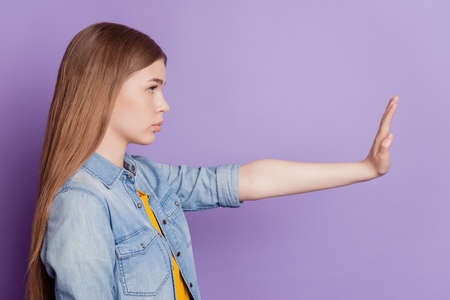 Photo of serious protester girl raise hand show stop sign look empty space side profileの写真素材