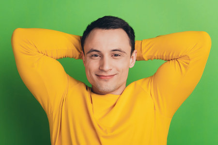 Portrait of positive cheerful nice guy hands head dream rest enjoy on green background