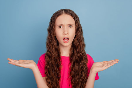 Portrait of lovely adorable reliable speechless girl hands hold empty space on blue background