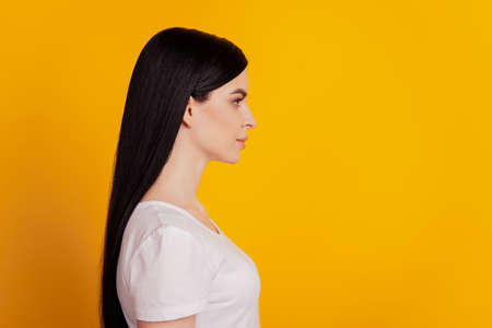 Profile side photo of minded intelligent girl confident look empty space isolated over yellow color backgroundの写真素材