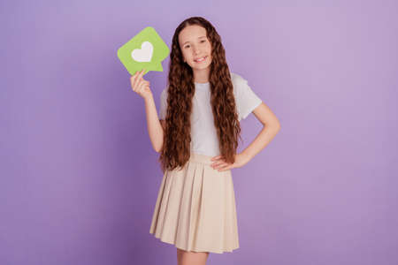Photo of young girl hold heart icon like isolated over purple backgroundの写真素材