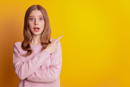 Photo of adviser excited girl finger direct empty space open mouth on yellow background