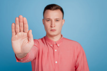 Portrait of strict handsome guy raise palm show refuse sign gesture rejection conceptの写真素材