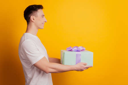 Profile portrait of delivery courier guy hold persent give look blank space on yellow backgroundの写真素材