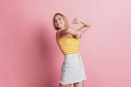 Portrait of carefree lady dance have fun look side on pink backgroundの写真素材