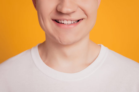 Young man with beautiful smile on yellow background