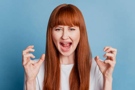 Angry girl screaming isolated on blue backgroundの写真素材