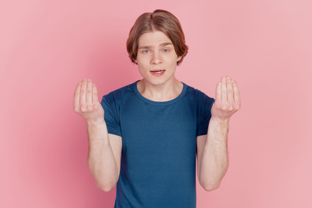 Photo of young guy unhappy sad upset gesture hands angry offended conflict isolated over pink color...