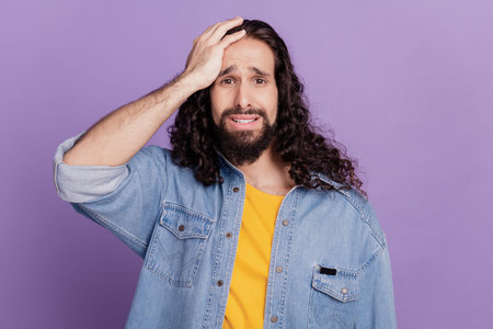 Portrait of a sad man have mistake failure hand head on violet background