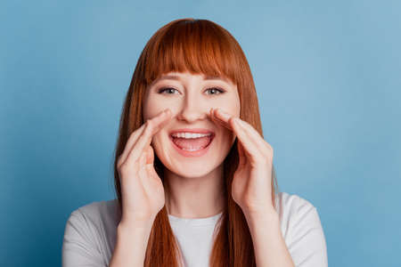 Portrait of woman mouth palm whisper gossip isolated on blue backgroundの写真素材