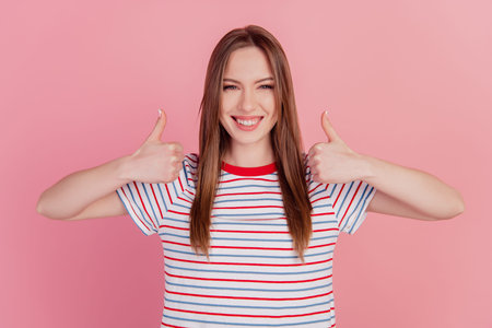 Photo of positive reliable lady raise thumbs up toothy beaming smile approve choice on pink...