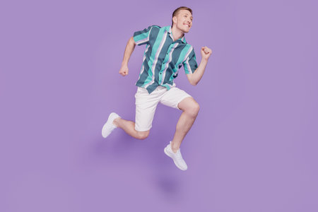 Profile portrait of sportive cheerful funny guy jump run hurry on purple background