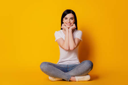 Full body photo of young girl sitting on floor dream rest isolated bright vivid yellow color backgroundの写真素材