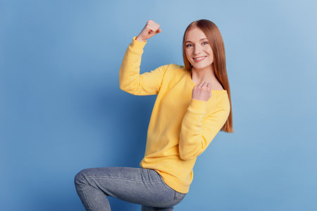 Portrait of nice attractive positive lady raise arms achievement concept on blue backgroundの写真素材