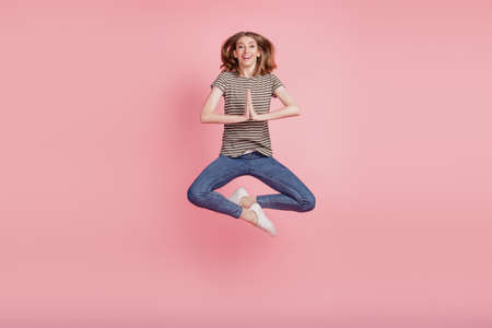 Full size photo of young woman happy positive smile ask wish dream please wait gift excited jump isolated over pink color backgroundの写真素材