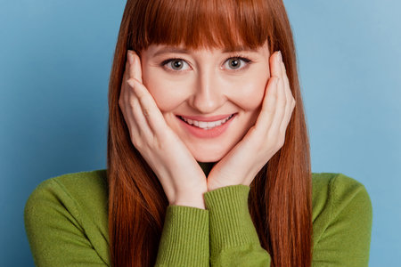 Photo of joyful young woman with beaming smile isolated on blue background