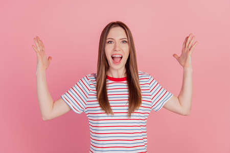 Portrait of funky crazy surprised lady raise palms yell good mood winner concept on pink backgroundの写真素材