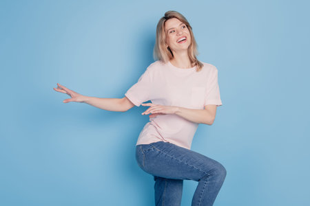 Portrait of dreamy inspired lady look empty space dance free time concept on blue background
