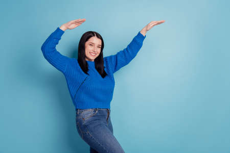 Full body photo of young cheerful girl dancing have fun disco music isolated on blue colored backgroundの写真素材