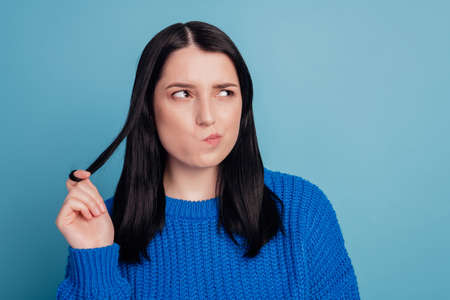 Photo portrait of pretty girl looking at empty space think minded deep isolated on blue color backgroundの写真素材