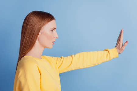 Profile portrait of focused protester lady show stop virus gesture on blue backgroundの写真素材