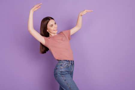 Photo of cheerful carefree girl dancing disco isolated over violet backgroundの写真素材