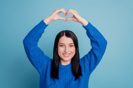 Photo of attractive lovely young girl showing heart figure love valentine day isolated over blue...