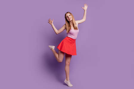 Portrait of carefree party disco dancer lady dance have fun wear pink top red short skirt on violet backgroundの写真素材
