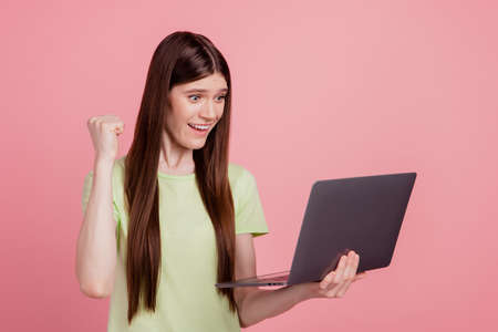 Profile sie photo of young attractive girl happy positvie smile look laptop rejoice victory success isolated over pink color backgroundの写真素材