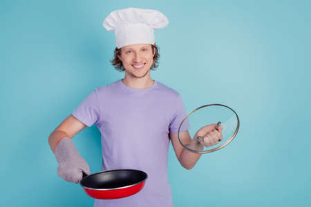 Confident positive handsome redhead chef open sauce pan prepare cook fry steakの写真素材