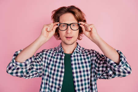 Close-up portrait of smart clever guy touching specs vision isolated over pink color pastel backgroundの写真素材