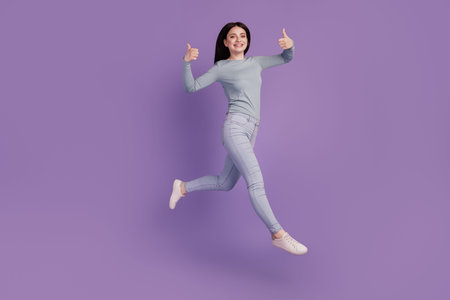 Full body profile side photo of young excited girl jump up show thumb-up like recommend ad isolated...