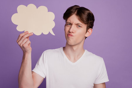 Portrait of moody negative guy hold poster think advert news information isolated over purple color...