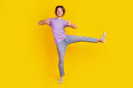 Positive reliable young guy stand one leg raise thumbs upの写真素材