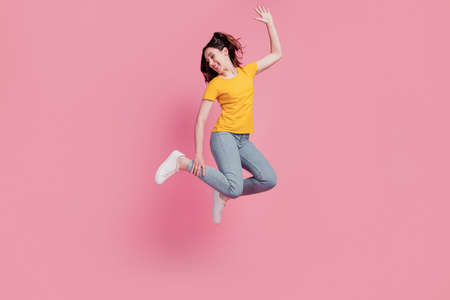 Photo of positive nice crazy brunette woman jump enjoy flight wear casual jeans clothes on pink backgroundの写真素材